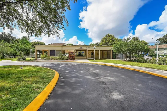 a view of house with swimming pool and a yard