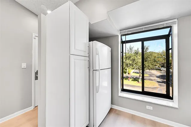 a view of a kitchen with a refrigerator and window