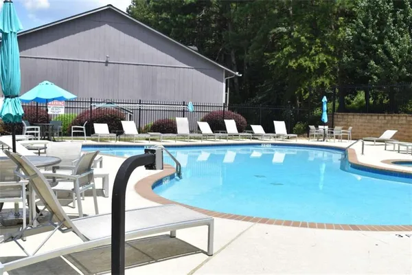 a view of a house with pool and chairs