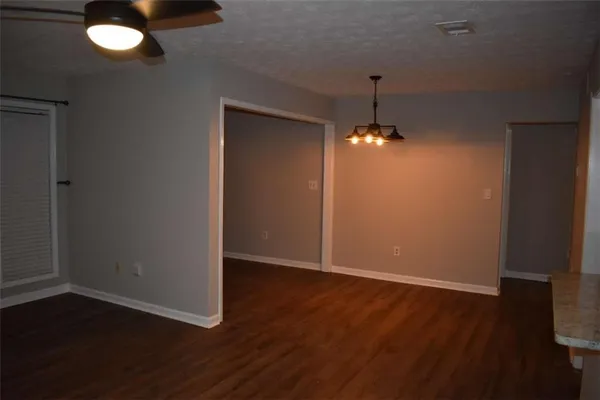 an empty room with wooden floor windows and exposed bricks
