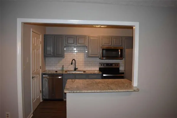 a kitchen with stainless steel appliances granite countertop a sink and a stove top oven