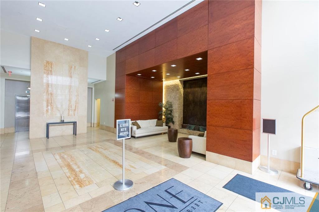 1 Spring Street, Unit 1704 New Brunswick, NJ 08901 - Photo 4 of 23 a lobby with furniture and a rug