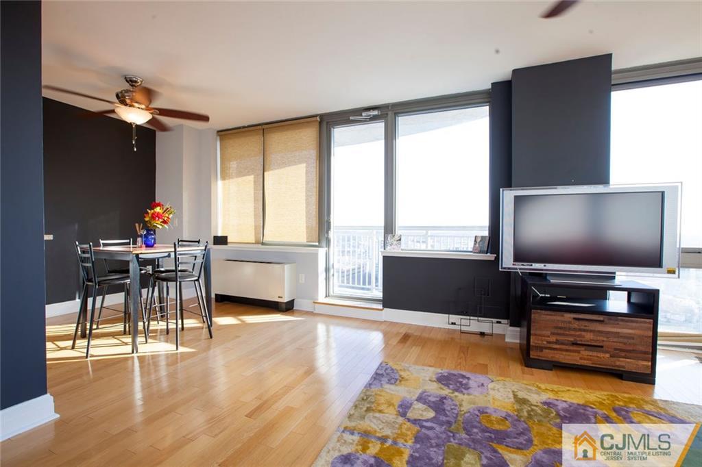 1 Spring Street, Unit 1704 New Brunswick, NJ 08901 - Photo 7 of 23 a living room with furniture and a flat screen tv