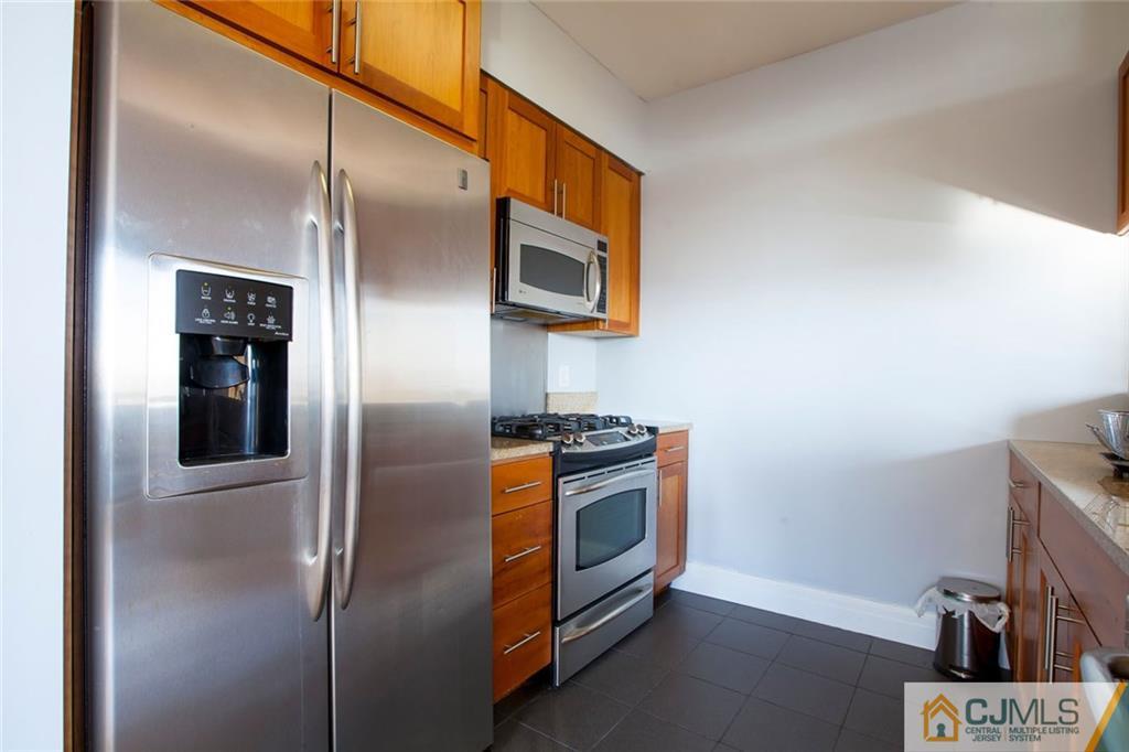 1 Spring Street, Unit 1704 New Brunswick, NJ 08901 - Photo 8 of 23 a kitchen with stainless steel appliances granite countertop a refrigerator and a stove