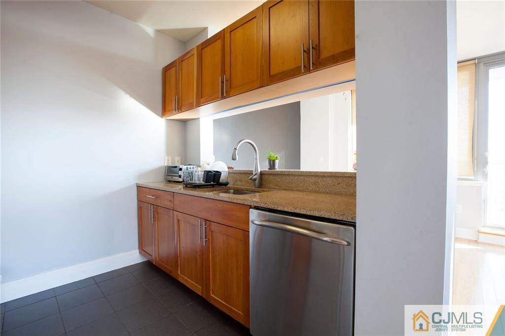 1 Spring Street, Unit 1704 New Brunswick, NJ 08901 - Photo 9 of 23 a kitchen with stainless steel appliances granite countertop a sink and a cabinets