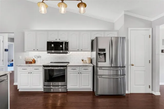 a kitchen with stainless steel appliances and wooden floor