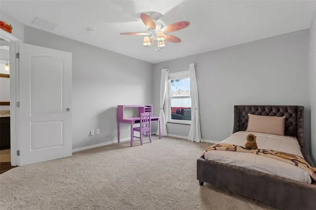 a bedroom with a bed a chair and a chandelier