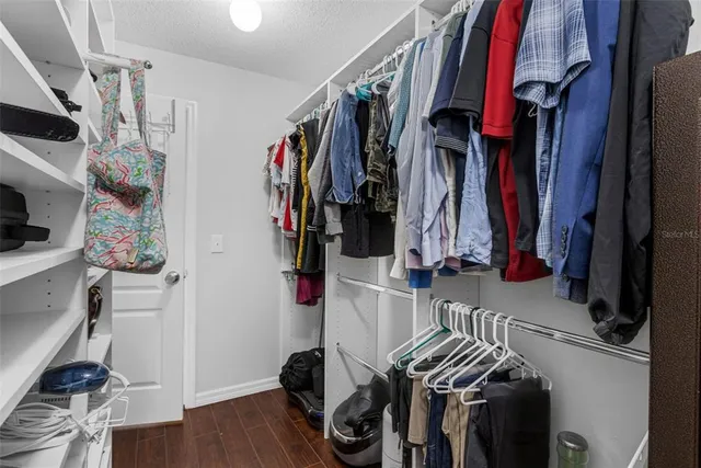 a view of walk in closet with clothes and shoes
