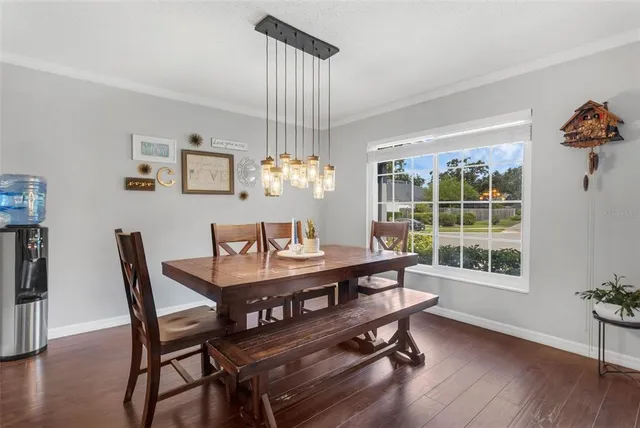 a dining room with furniture a chandelier and wooden floor