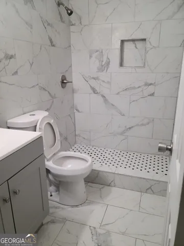 a white toilet sitting next to a white sink