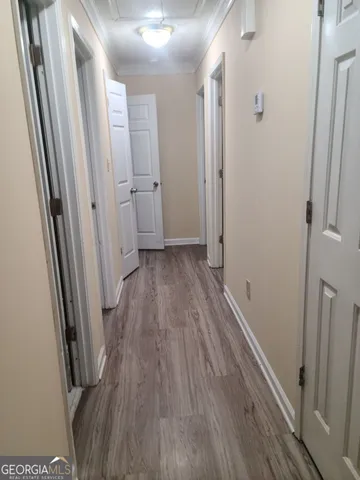 a view of a hallway with wooden floor and a glass door