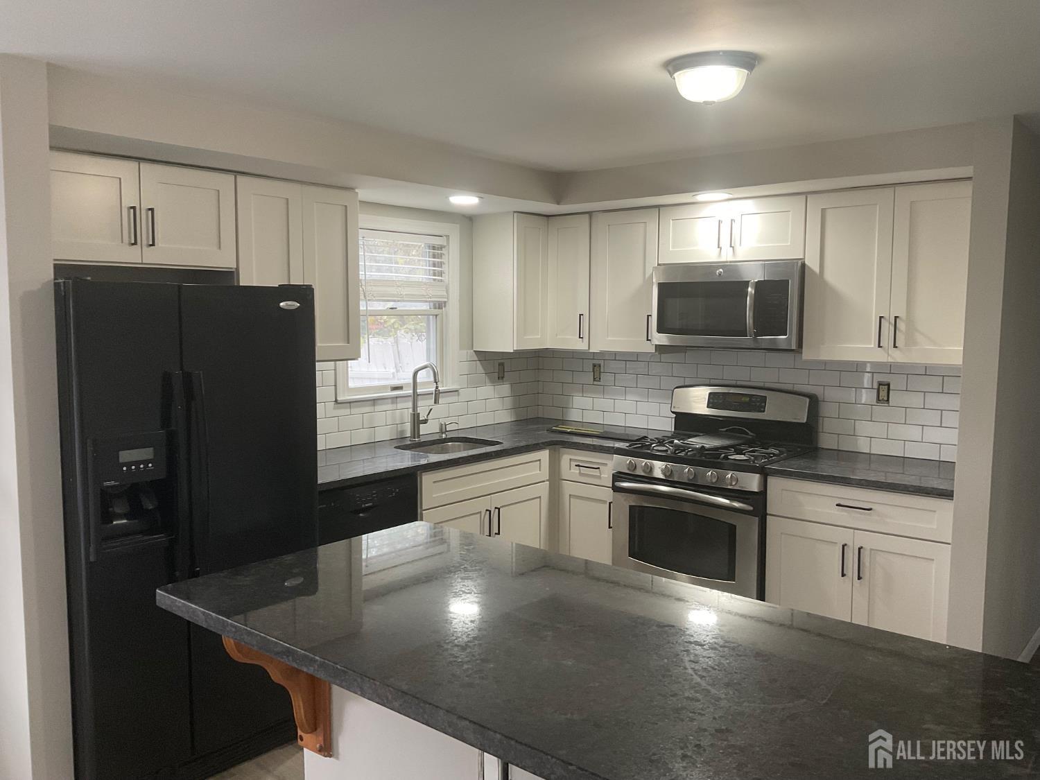 939 Englishtown Road Old Bridge, NJ 08857 - Photo 2 of 12 a kitchen with stainless steel appliances granite countertop a refrigerator a stove top oven a sink and dishwasher