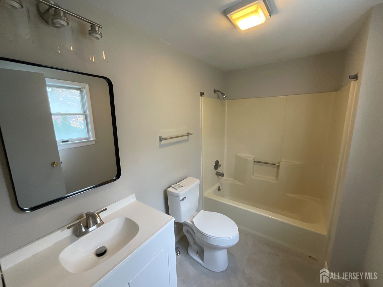939 Englishtown Road Old Bridge, NJ 08857 - Photo 4 of 12 a bathroom with a toilet a sink a tub and mirror