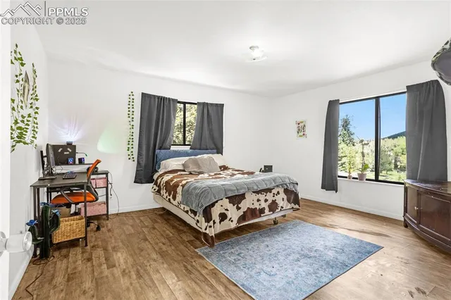 a bed sitting in a bedroom next to a window with a bookshelf