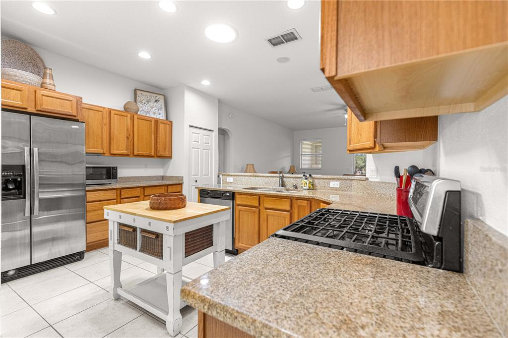 9317 Southwest 94th Loop Ocala, FL 34481 - Photo 13 of 40 a kitchen with stainless steel appliances granite countertop a sink stove and refrigerator