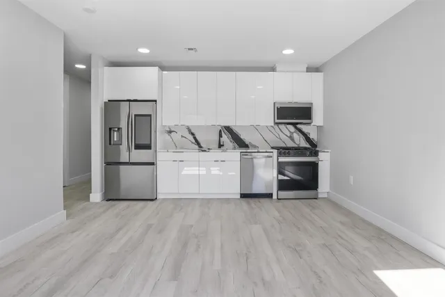 a kitchen with stainless steel appliances a refrigerator and a stove top oven