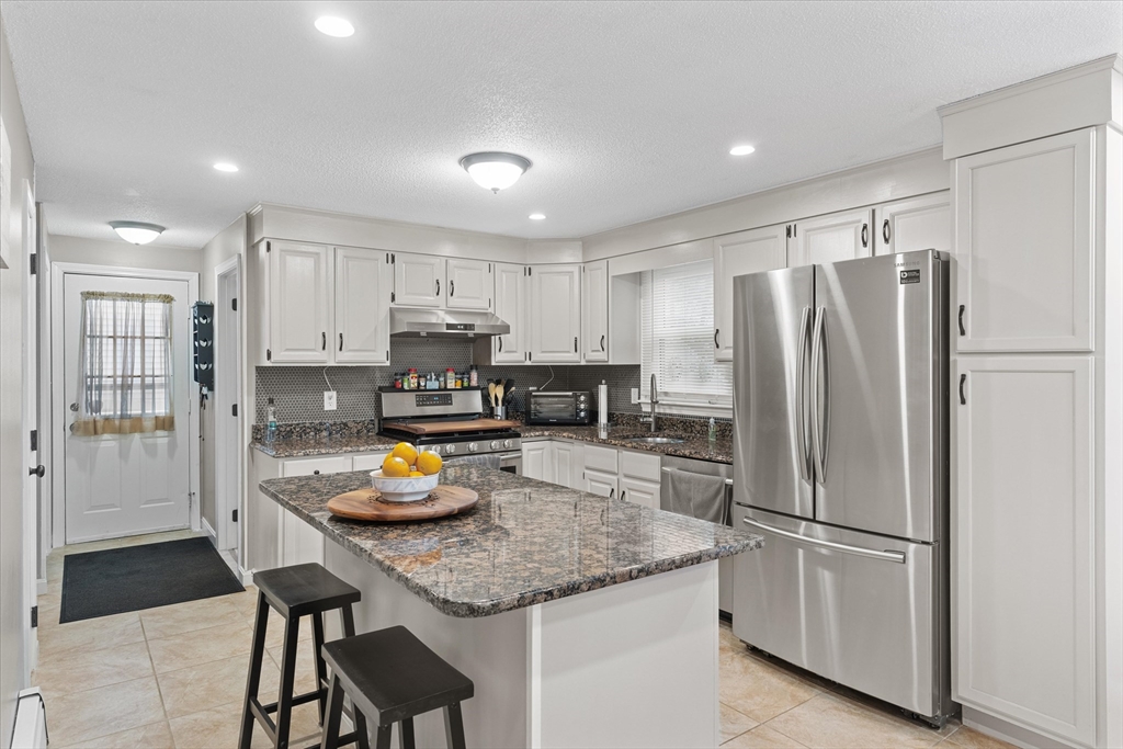 62 Valley Road Dracut, MA 01826 - Photo 7 of 35 a kitchen with stainless steel appliances granite countertop a refrigerator and a stove top oven
