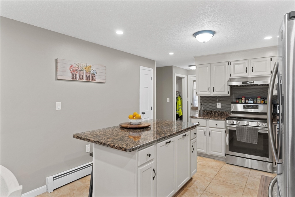 62 Valley Road Dracut, MA 01826 - Photo 9 of 35 a kitchen with stainless steel appliances granite countertop a stove a sink and a refrigerator