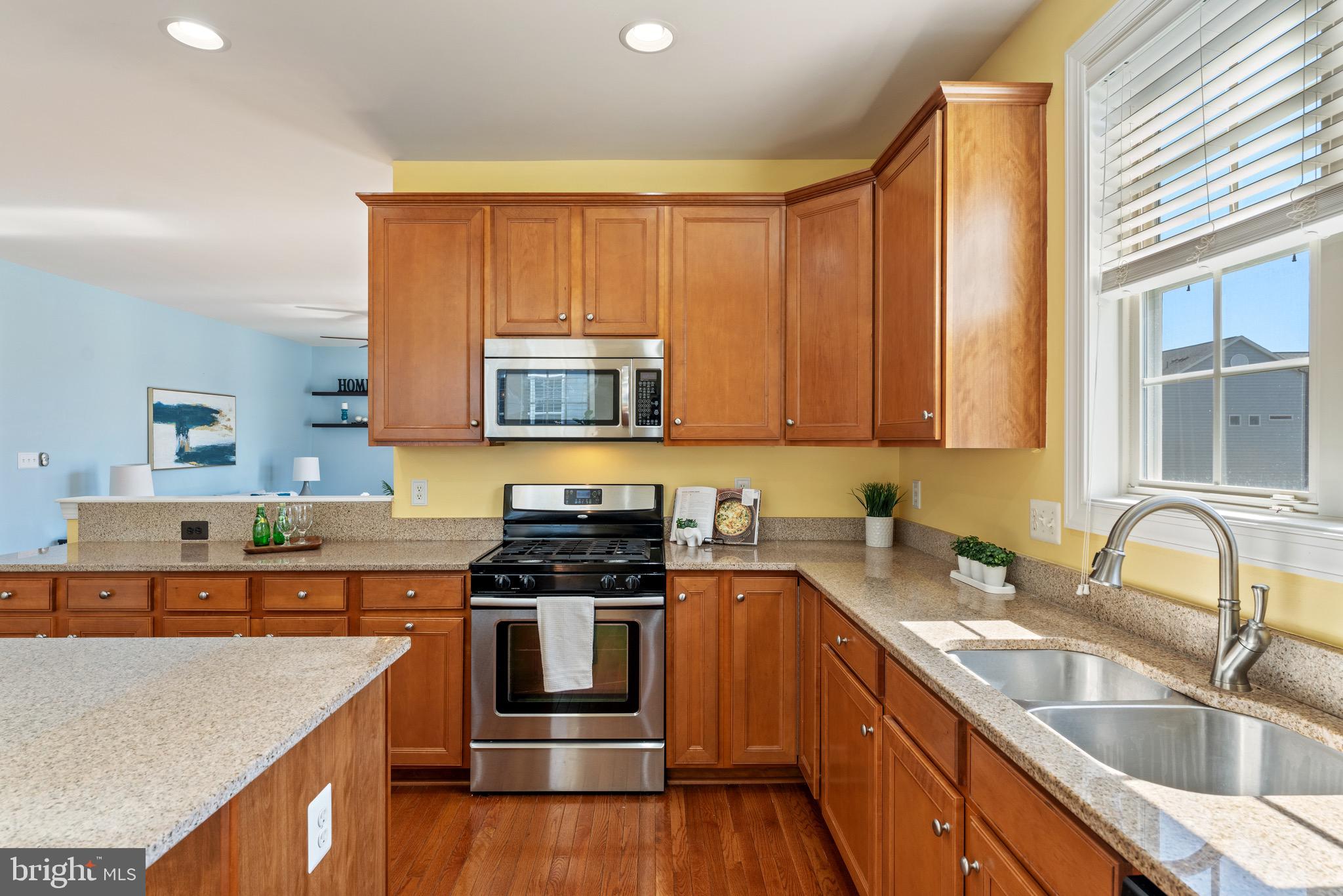 16277 Jetty Loop Woodbridge, VA 22191 - Photo 21 of 92 a kitchen with stainless steel appliances a sink a stove a microwave and wooden cabinets