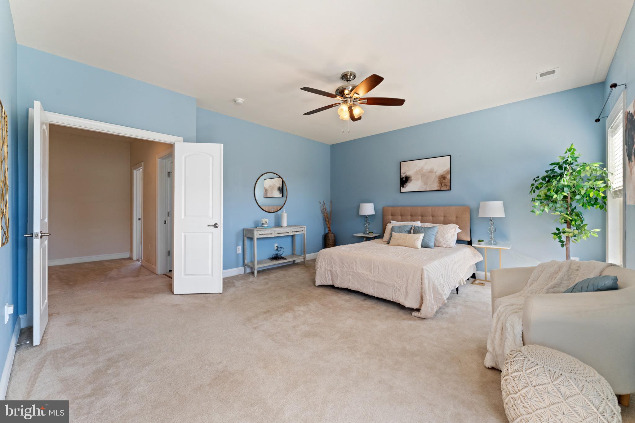 16277 Jetty Loop Woodbridge, VA 22191 - Photo 39 of 92 a spacious bedroom with a bed and a chandelier