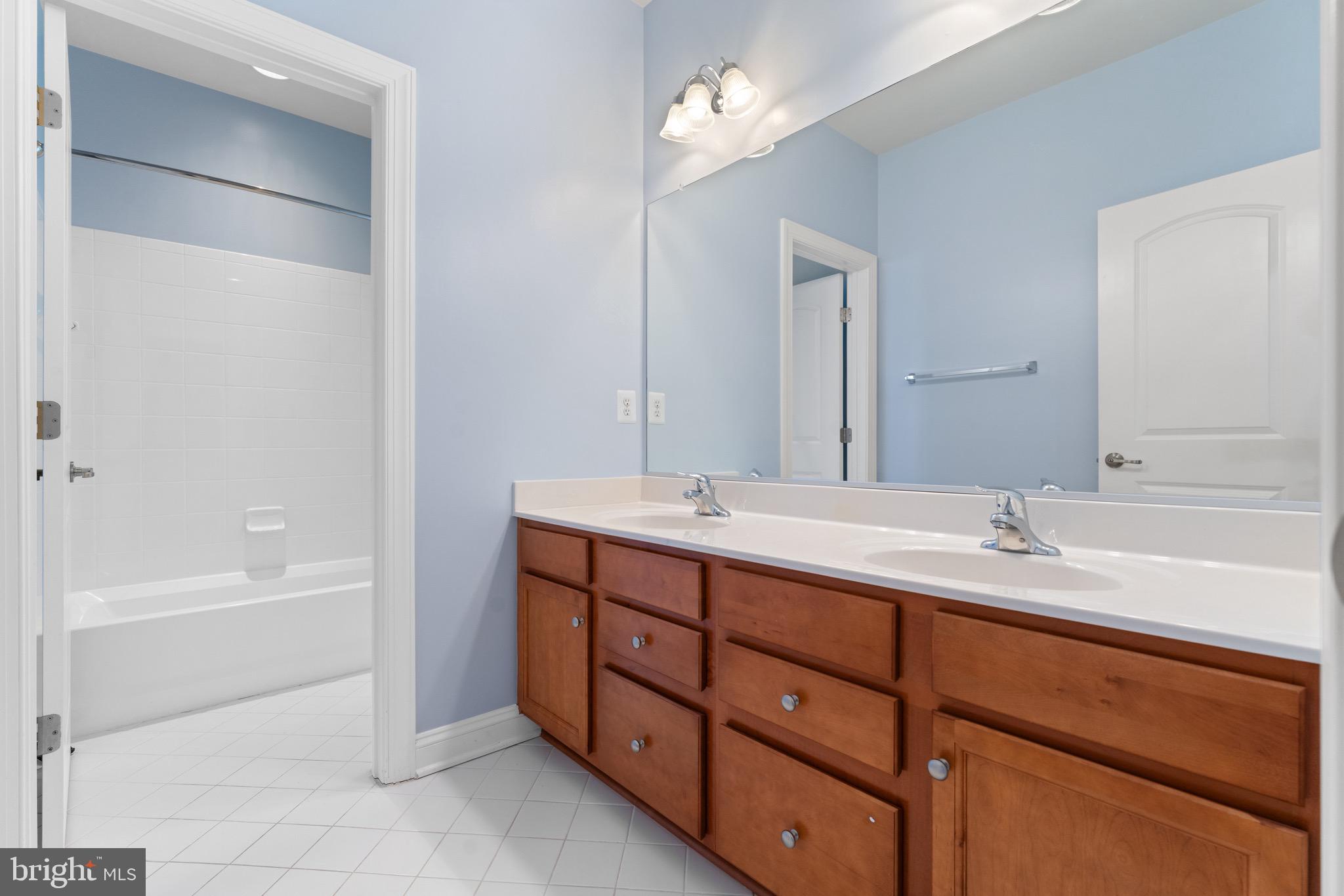 16277 Jetty Loop Woodbridge, VA 22191 - Photo 48 of 92 a bathroom with a tub sink and a mirror