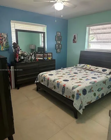 a bedroom with a bed mirror and window