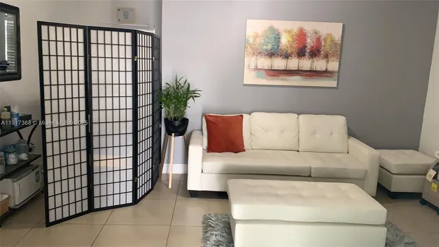 a living room with a couch and a potted plant