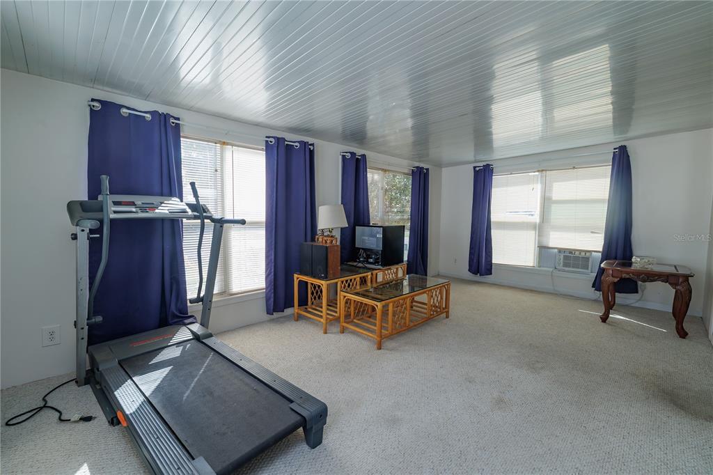 412 Osprey Drive Sebastian, FL 32976 - Photo 12 of 35 a living room with furniture gym equipment and a flat screen tv