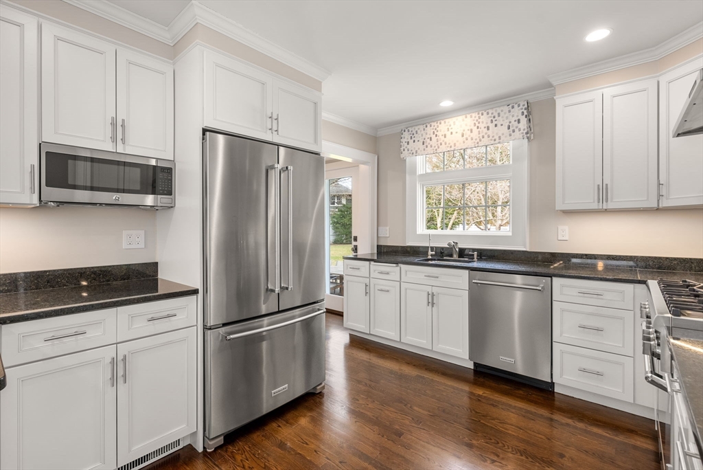 11 Mossfield Road Newton, MA 02468 - Photo 13 of 32 a kitchen with granite countertop stainless steel appliances a refrigerator cabinets and wooden floor
