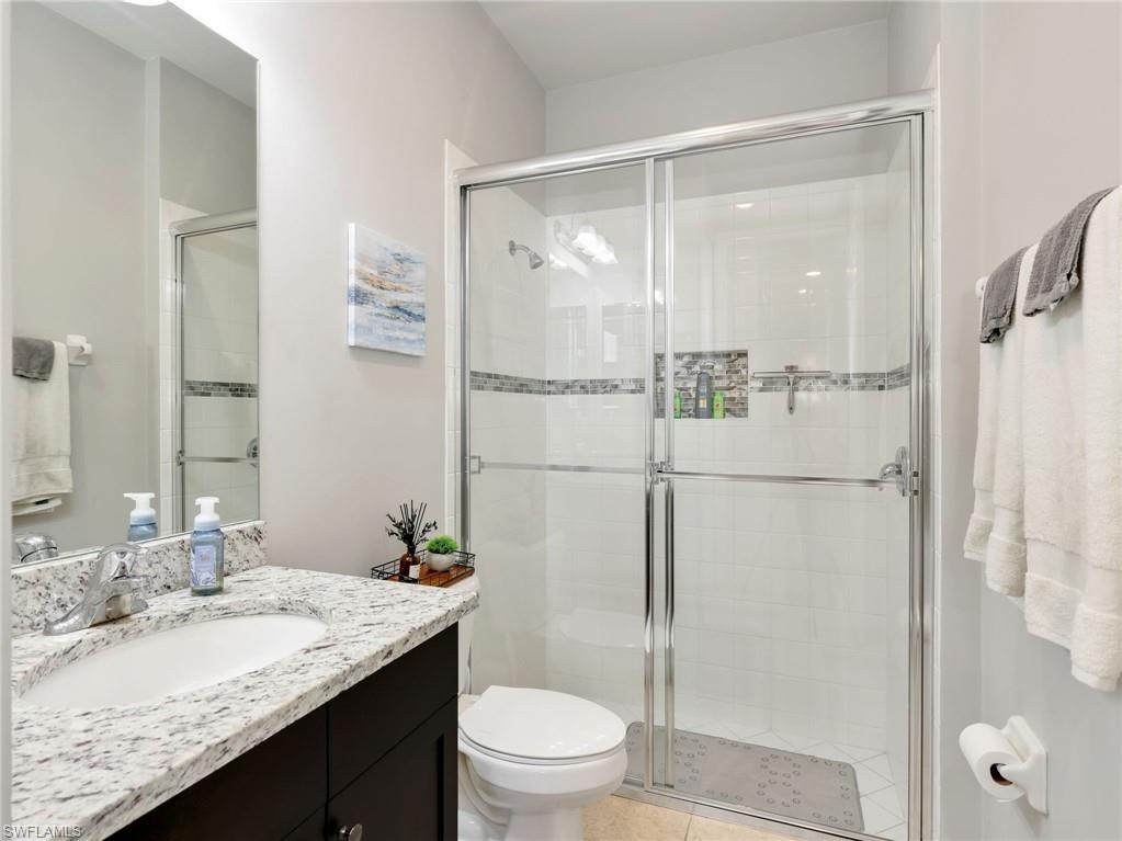 2756 Crystal Way Naples, FL 34119 - Photo 40 of 50 a bathroom with a granite countertop sink toilet and shower
