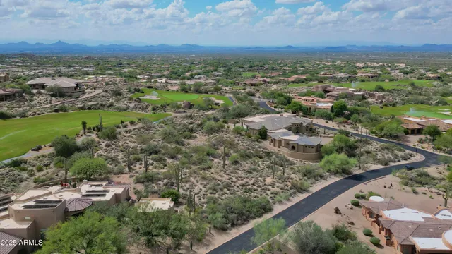 an aerial view of residential houses with outdoor space and trees