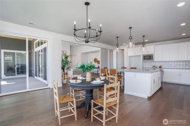 a view of a dining room and livingroom with furniture wooden floor a chandelier