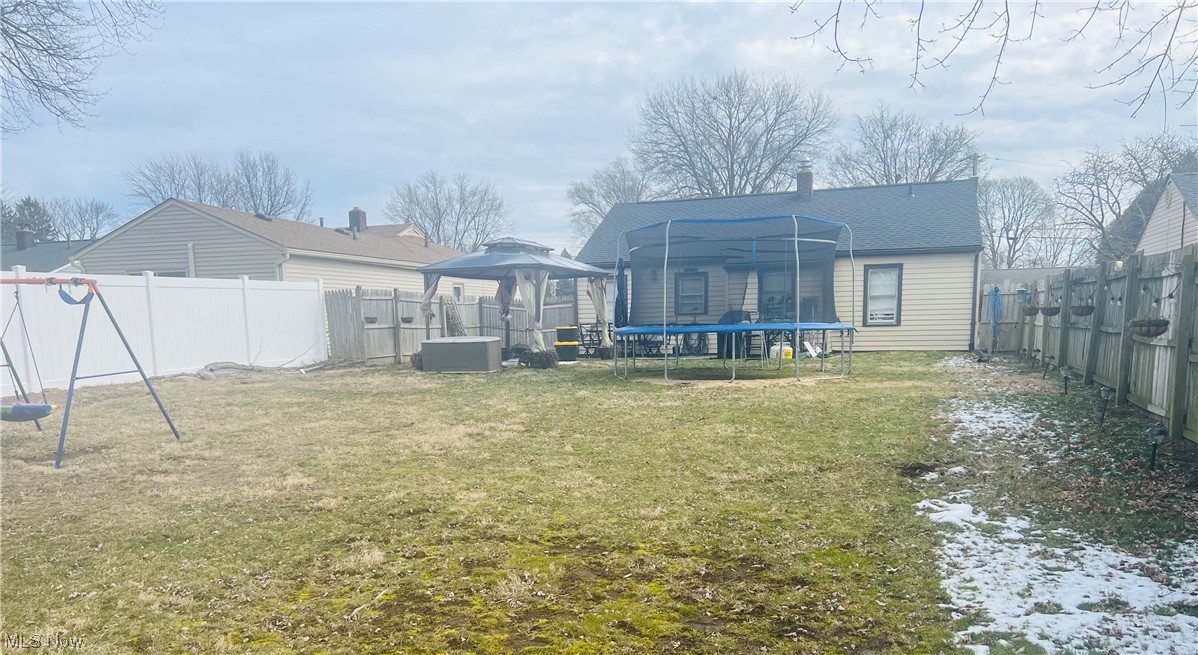 146 Stephens Road Akron, OH 44312 - Photo 28 of 31 Rear view of property with a yard and a trampoline