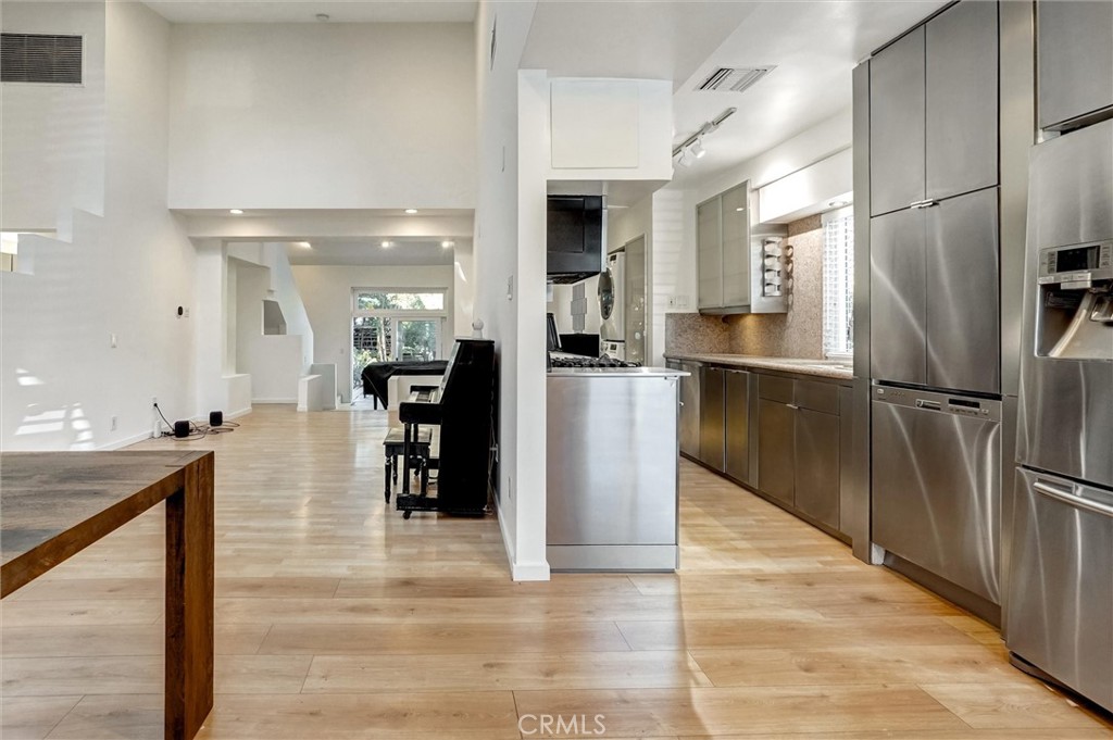 22037 Ybarra Road Woodland Hills, CA 91364 - Photo 11 of 32 a kitchen with stainless steel appliances kitchen island granite countertop a refrigerator and a sink