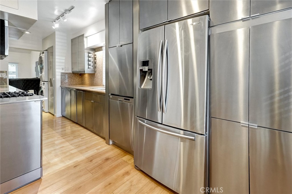 22037 Ybarra Road Woodland Hills, CA 91364 - Photo 12 of 32 a kitchen with stainless steel appliances a refrigerator and wooden floor
