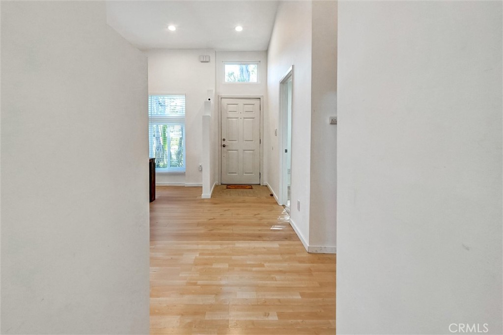 22037 Ybarra Road Woodland Hills, CA 91364 - Photo 15 of 32 a view of a hallway with wooden floor