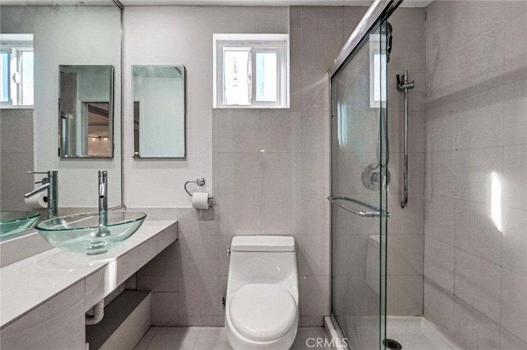 22037 Ybarra Road Woodland Hills, CA 91364 - Photo 25 of 32 a bathroom with a toilet a sink and mirror