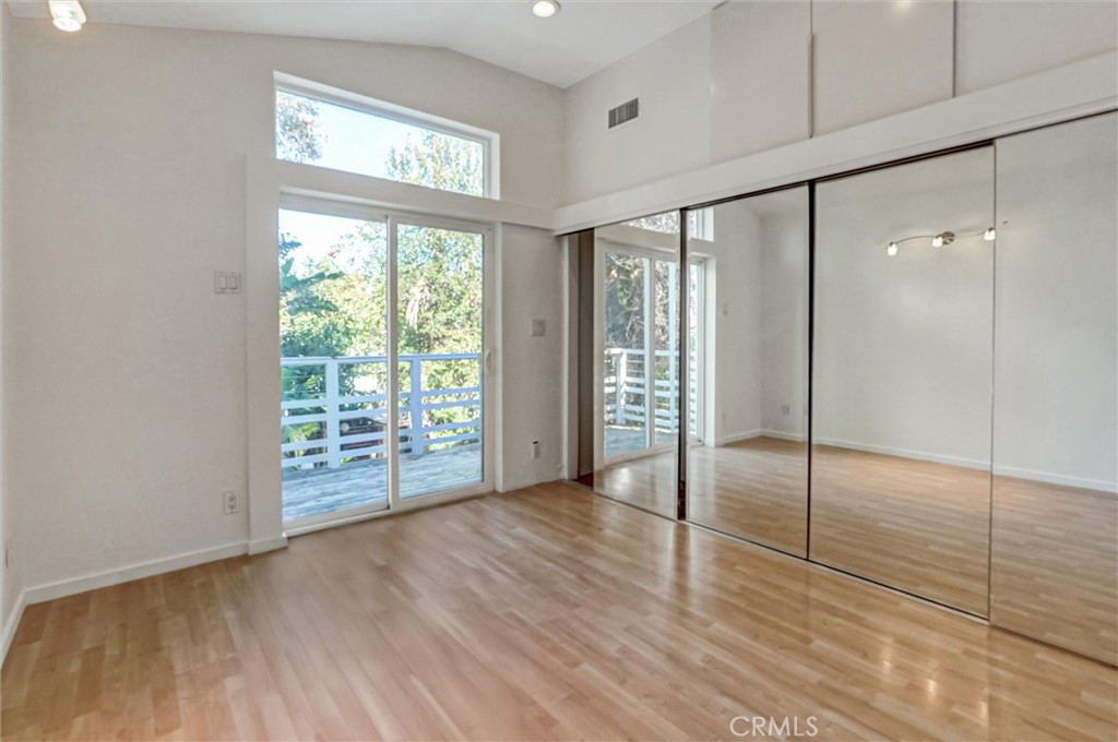 22037 Ybarra Road Woodland Hills, CA 91364 - Photo 26 of 32 a view of an empty room with wooden floor and a window