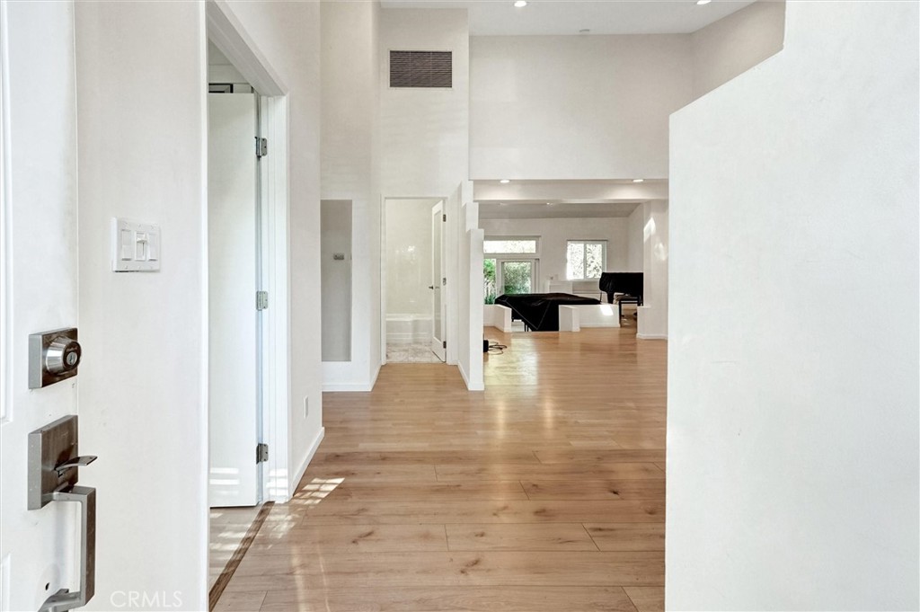22037 Ybarra Road Woodland Hills, CA 91364 - Photo 4 of 32 a view of a hallway with a view of living room with windows