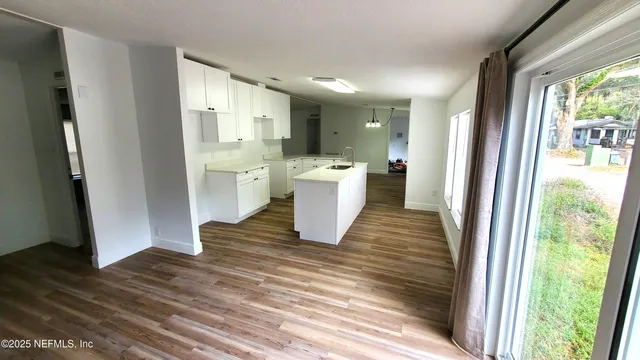 a kitchen with a white refrigerator and wooden floor