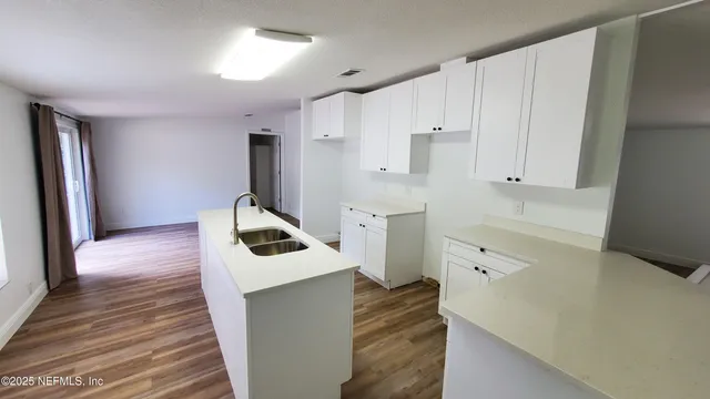 a kitchen with white cabinets and sink
