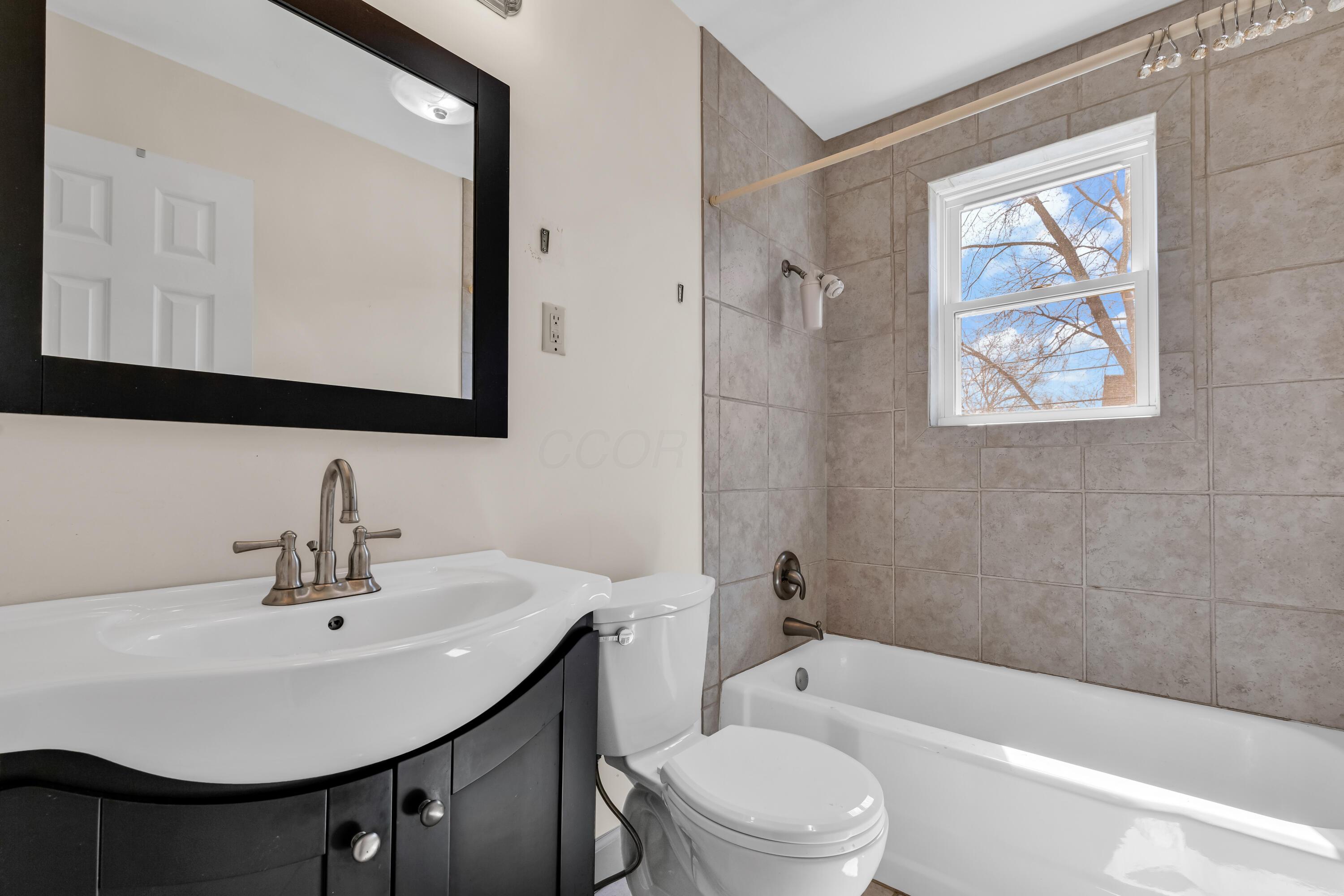 2033 Zollinger Road Columbus, OH 43221 - Photo 24 of 44 • Ceramic tile flooring
• Ivory painted walls
• Enclosed vanity with single
bowl, cultured marble
sinktop
• Studio lighting strip
• Tub/shower combination
with ceramic tile surround
• Lighted ceiling exhaust