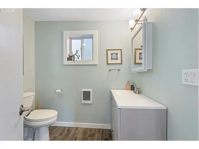 a bathroom with a toilet a sink and mirror