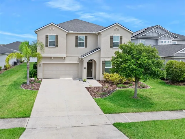 a front view of a house with a yard and trees