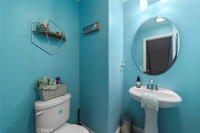 a bathroom with a toilet a sink and mirror