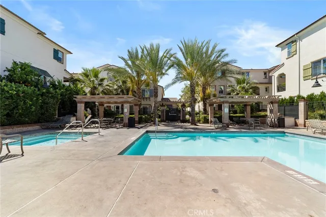 a view of backyard with swimming pool and seating space