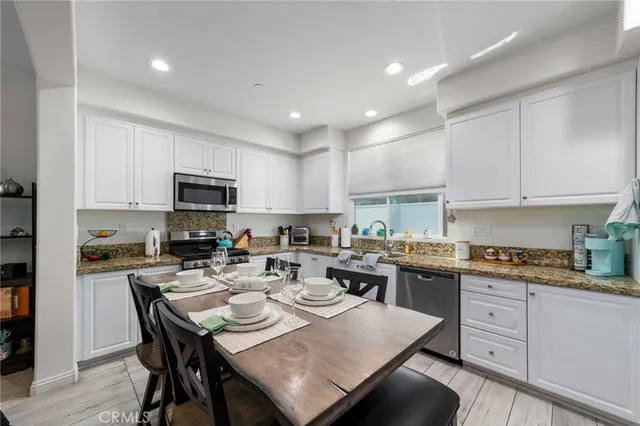 a kitchen with a stove a sink a dining table and chairs