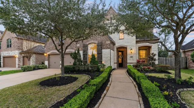 a front view of a house with yard and green space