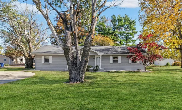 a tree in front of a white house