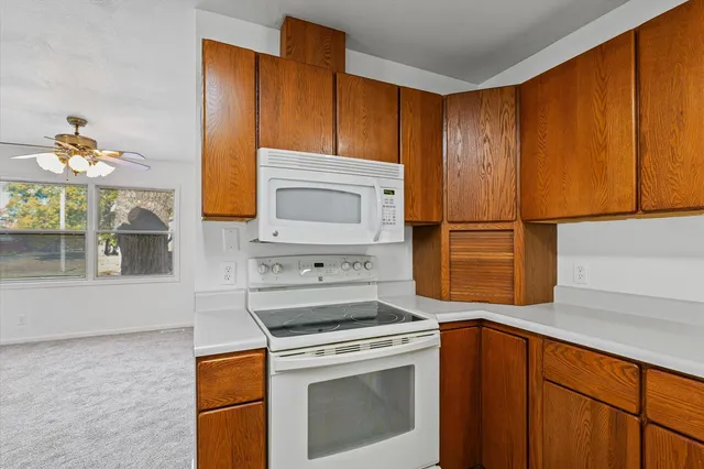 a kitchen with stainless steel appliances granite countertop wooden cabinets a stove a sink and a refrigerator